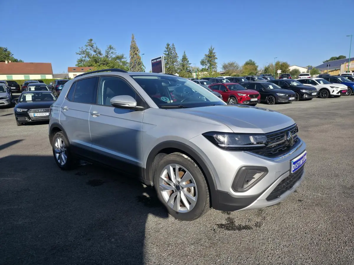 Volkswagen T-Cross gris métallisé vue 3/4 avant droit avec jantes alliage 17 pouces sur parking.