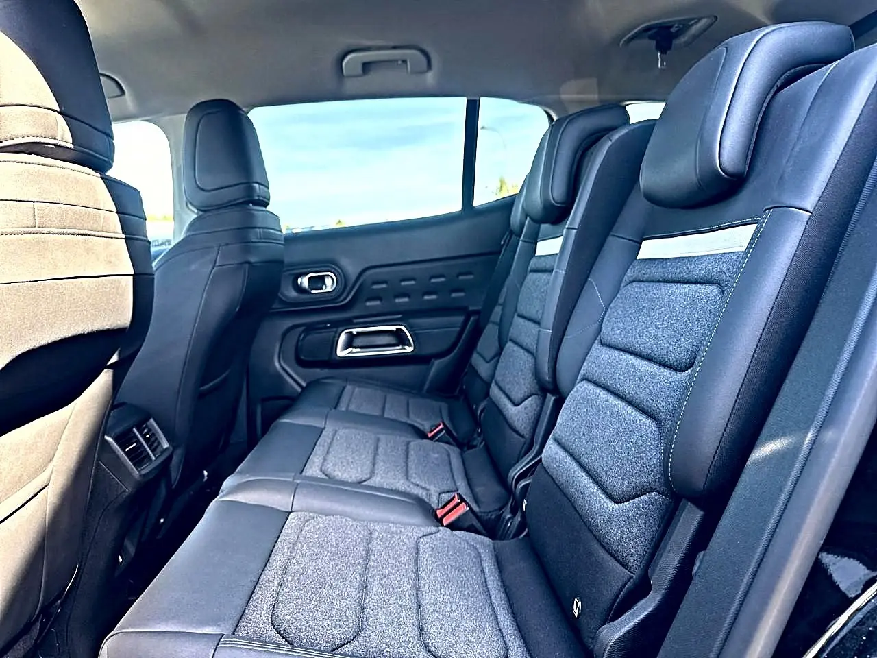 Vue intérieure de la 2e rangée de sièges individuels noirs et gris du Citroën C5 Aircross hybride 2025.