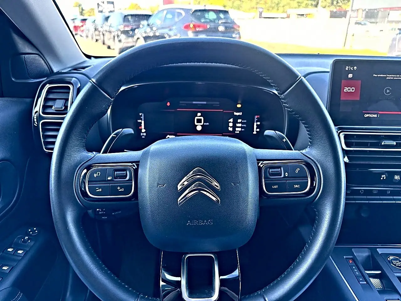 Vue intérieure centrée sur le volant cuir noir multifonction du Citroën C5 Aircross 2025 avec tableau de bord numérique.