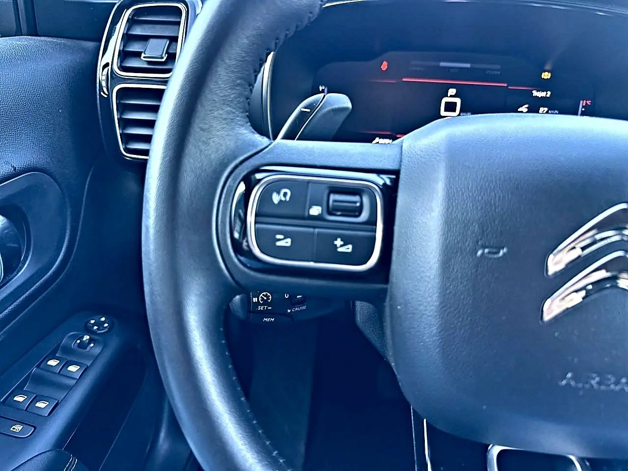 Gros plan sur le volant cuir multifonction noir côté gauche du Citroën C5 Aircross 2025 avec commandes intégrées.
