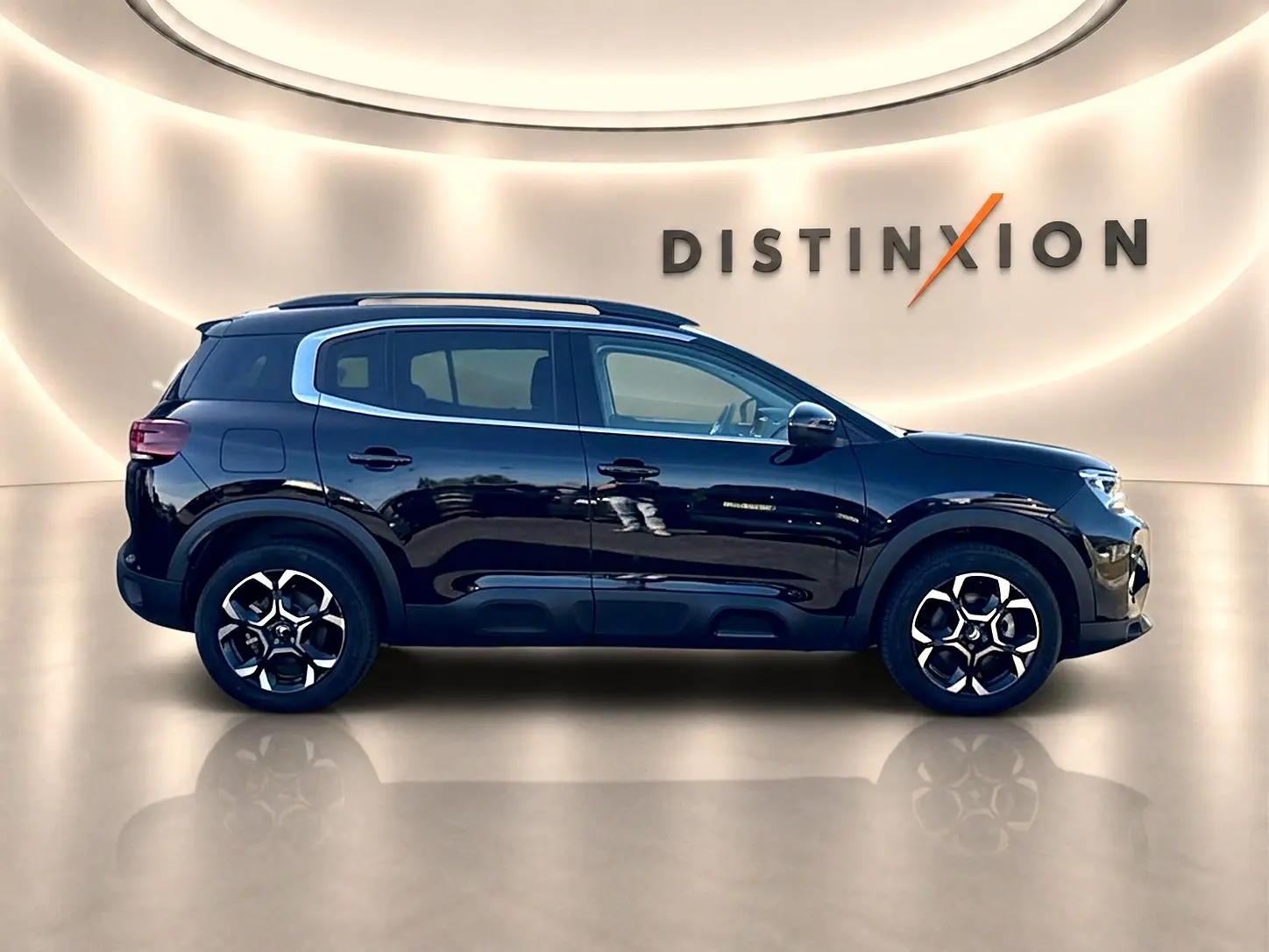 Profil côté gauche d'un Citroën C5 Aircross noir 2025 avec jantes alu et barres de toit en showroom.