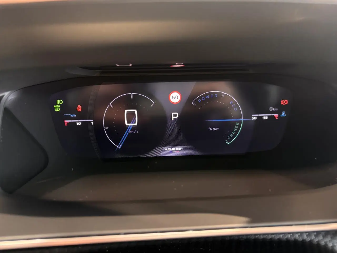 Vue rapprochée du combiné numérique Peugeot 2008 1.2i Hybrid 2025 affichant vitesse, mode et jauges énergie.