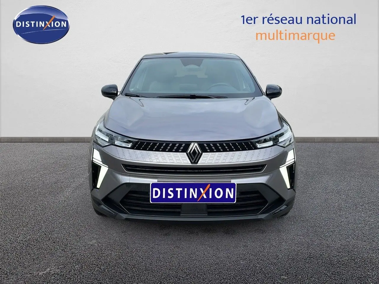 Vue frontale d'un Renault Captur gris Cassiopée métal avec toit noir, mettant en valeur sa calandre moderne et ses feux LED distinctifs.