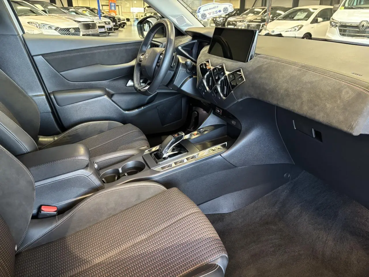 Intérieur avant droit du DS3 Crossback 2024, avec sellerie noire, tableau de bord en Alcantara et console centrale brillante.
