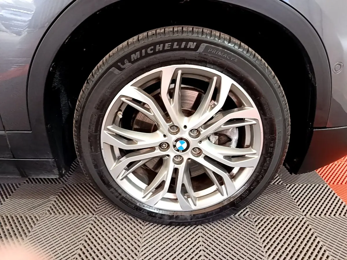 Gros plan sur la roue avant gauche grise d’un BMW X2 xDrive25e avec jante alliage et pneu Michelin.