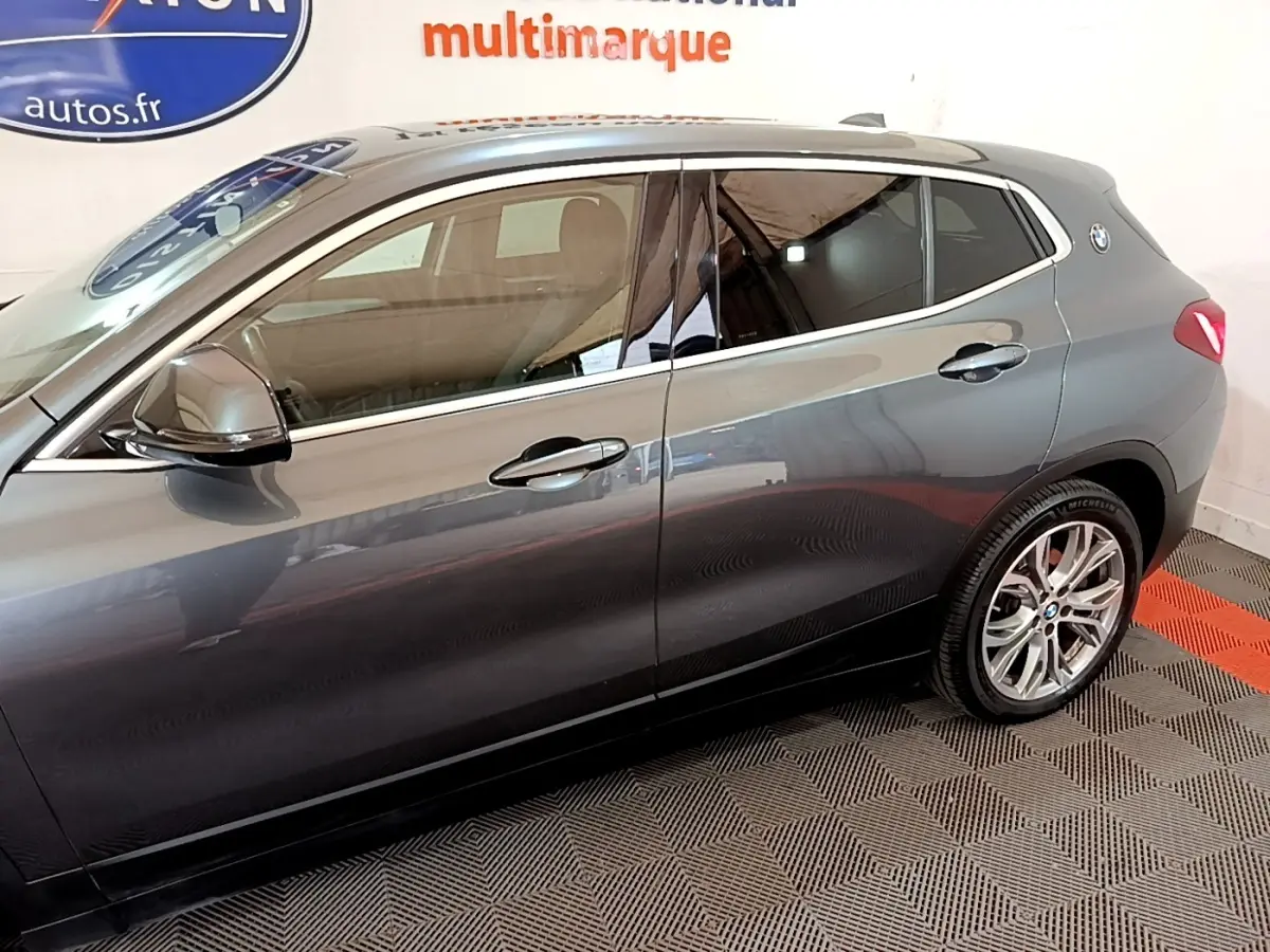 Vue latérale droite d'un BMW X2 hybride rechargeable gris métallisé avec jantes alliage et rétroviseurs assortis.
