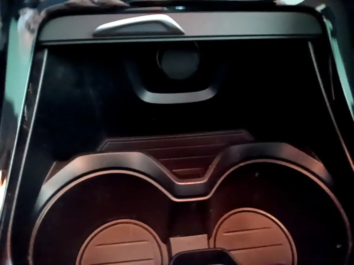 Gros plan sur les porte-gobelets noirs au centre de la console d'une BMW X2 hybride rechargeable 2020.