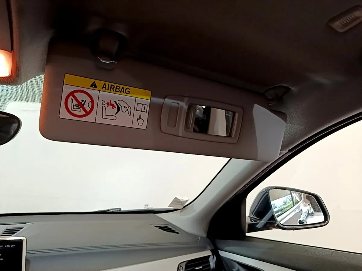 Vue intérieure côté conducteur du BMW X2 xDrive25e 2020, avec pare-soleil beige et rétroviseur latéral noir.