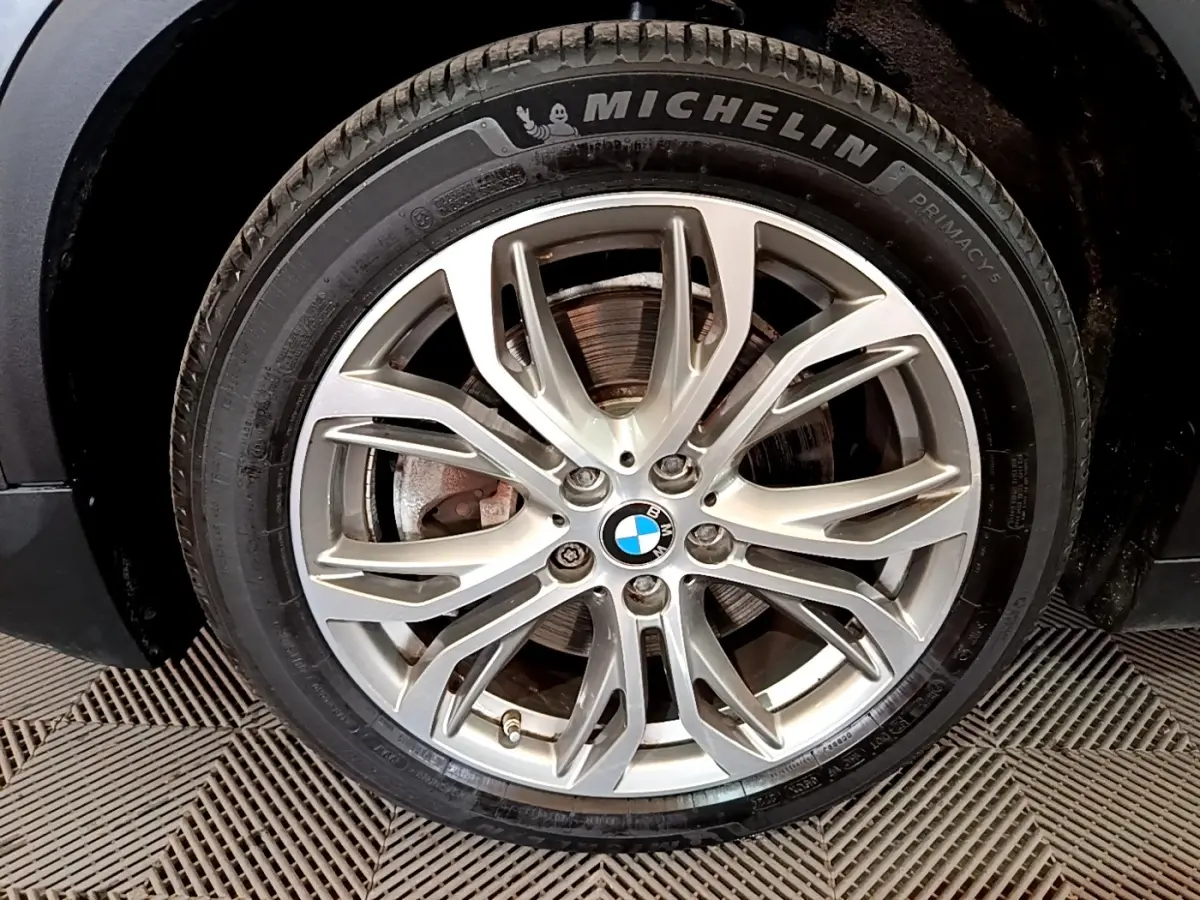 Gros plan sur la jante alliage argentée et pneu Michelin d'une BMW X2 xDrive25e hybride rechargeable, côté avant droit.