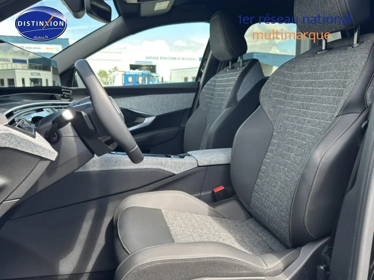 Vue intérieure côté conducteur du Peugeot 5008 Hybrid 145 allure e-dcs6 2025, sièges tissu gris et cuir noir.