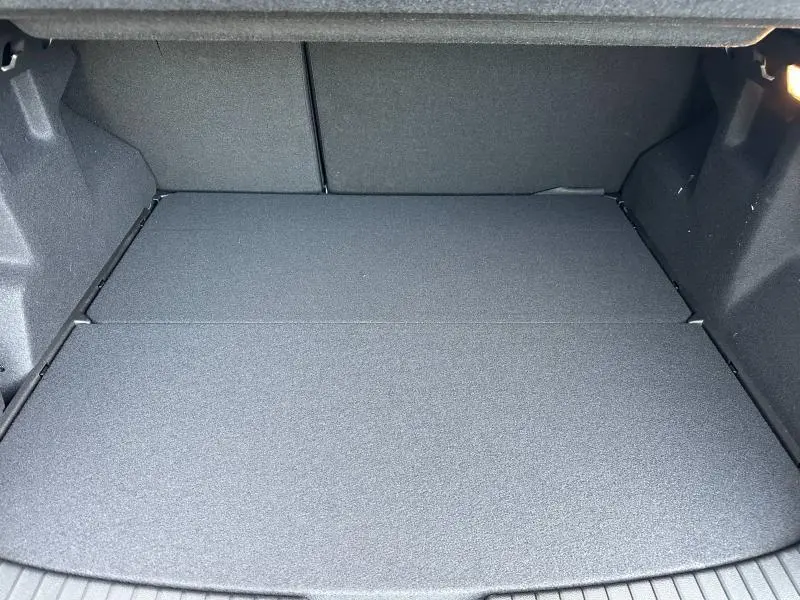 Coffre vide vu de face du Dacia Duster 1.8 hybrid 155ch Journey 2025, intérieur en tissu gris foncé.