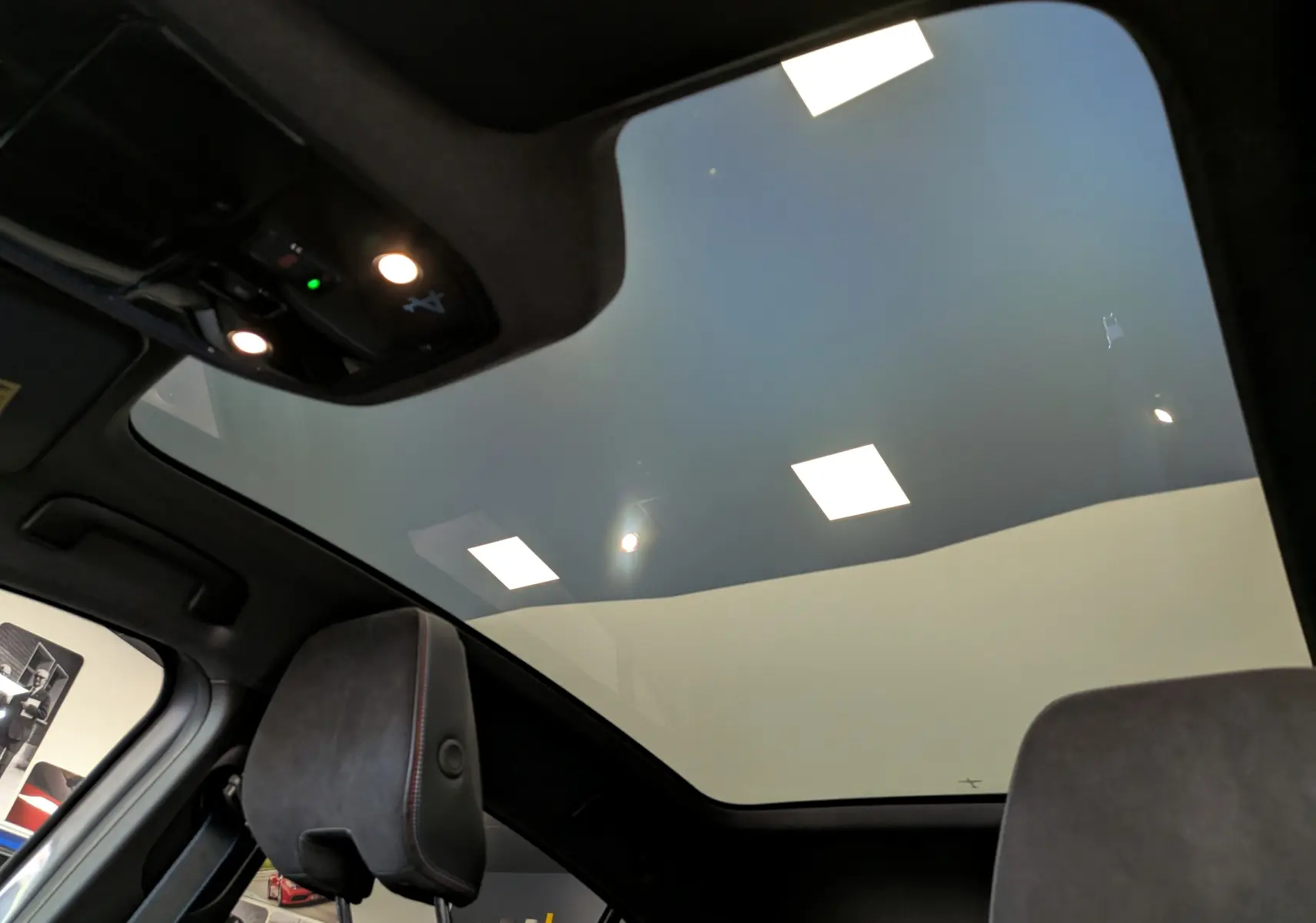 Vue intérieure du toit panoramique et des appuie-têtes avant du Renault Rafale gris Schiste, version hybride 2026.