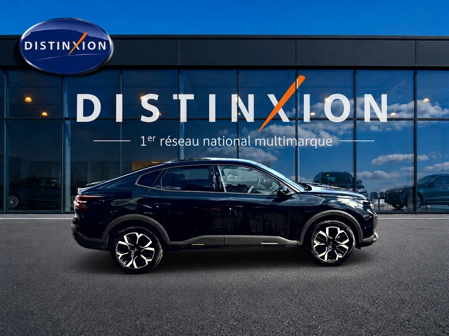Vue de profil côté gauche d'une Citroën C4 X noire 2025 avec jantes alliage et vitres arrière surteintées.