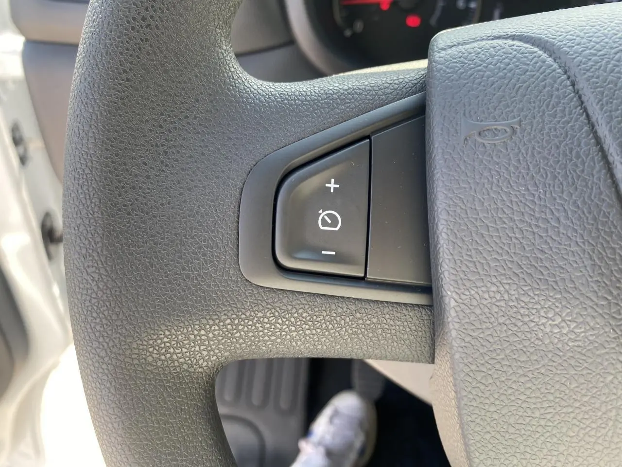 Gros plan sur le volant noir du Nissan Interstar blanc 2022, montrant les commandes de régulateur de vitesse.