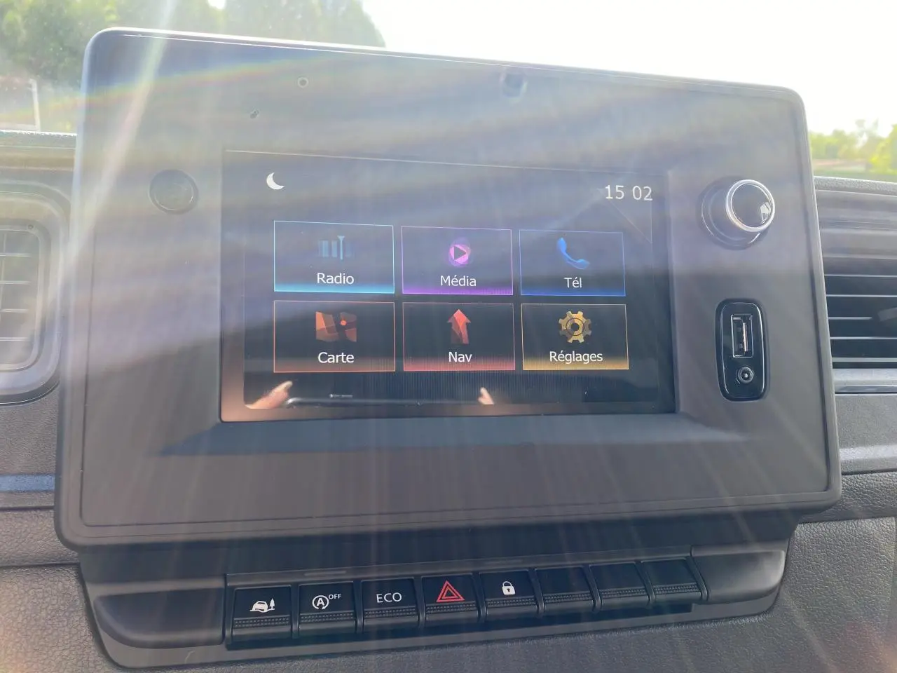 Écran tactile du système NissanConnect avec menu principal, port USB et commandes intégrées, intérieur du Nissan Interstar blanc.