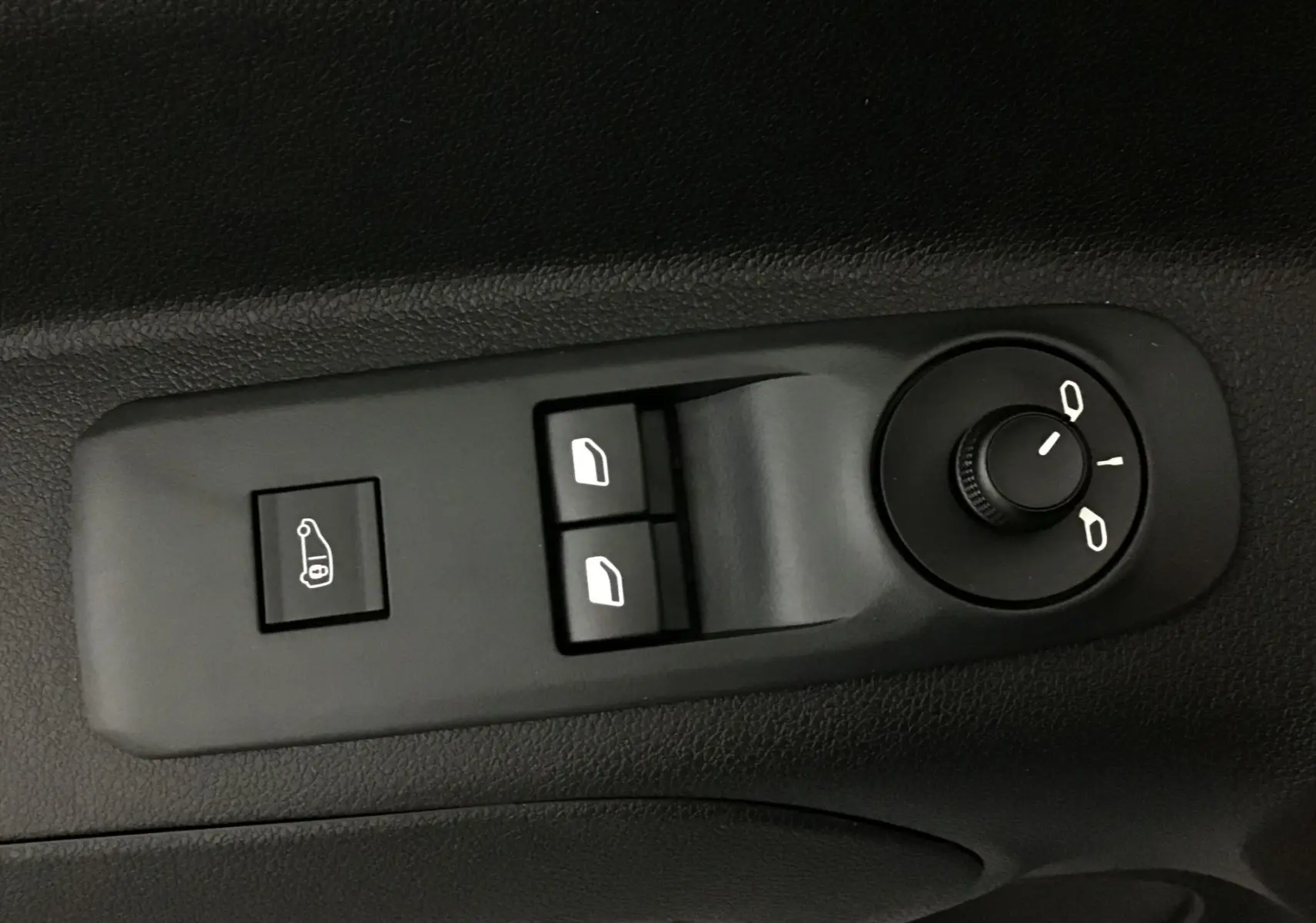 Panneau de commandes des vitres et rétroviseurs électriques sur la portière intérieure d'un Peugeot Partner blanc.