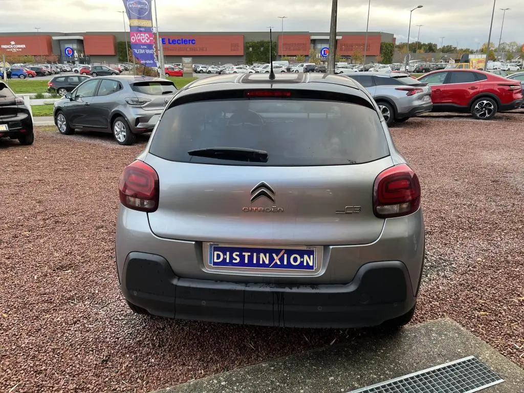 Vue arrière d'une Citroën C3 gris foncé de 2019 avec vitres surteintées et logo distinctif sur un parking.