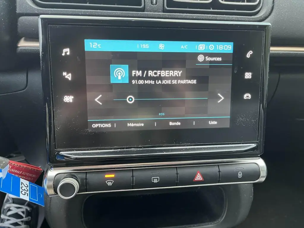 Écran tactile central de la Citroën C3 2019 affichant la radio FM RCFBERRY avec commandes climatisation et verrouillage en dessous.
