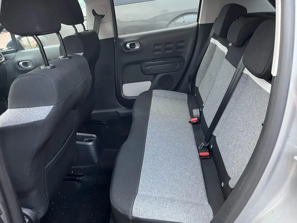 Vue intérieure côté droit sur la banquette arrière gris clair et noir de la Citroën C3 gris foncé de 2019.