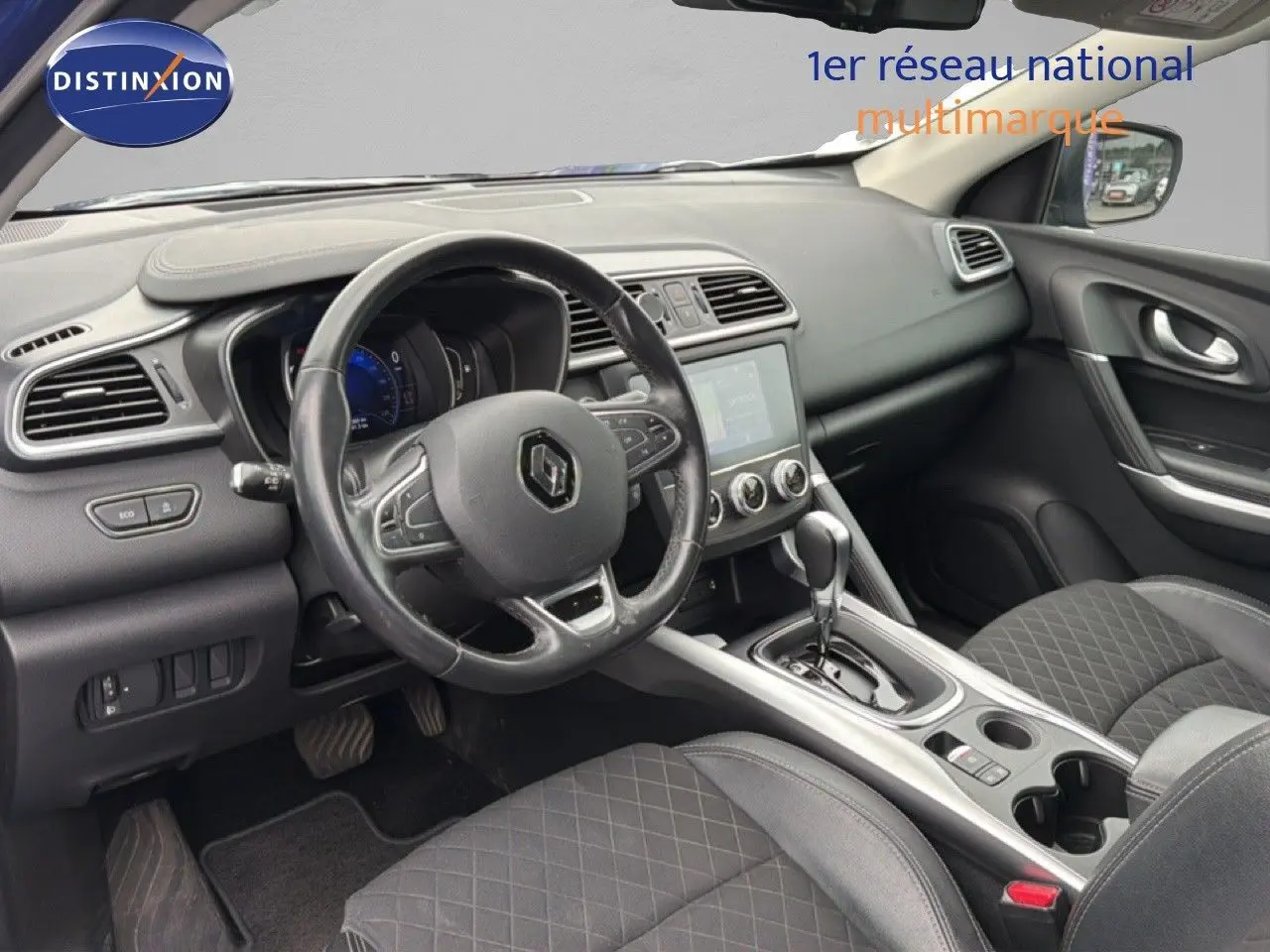 Vue intérieure côté conducteur du Renault Kadjar 2021, tableau de bord noir avec volant multifonction et console centrale moderne.