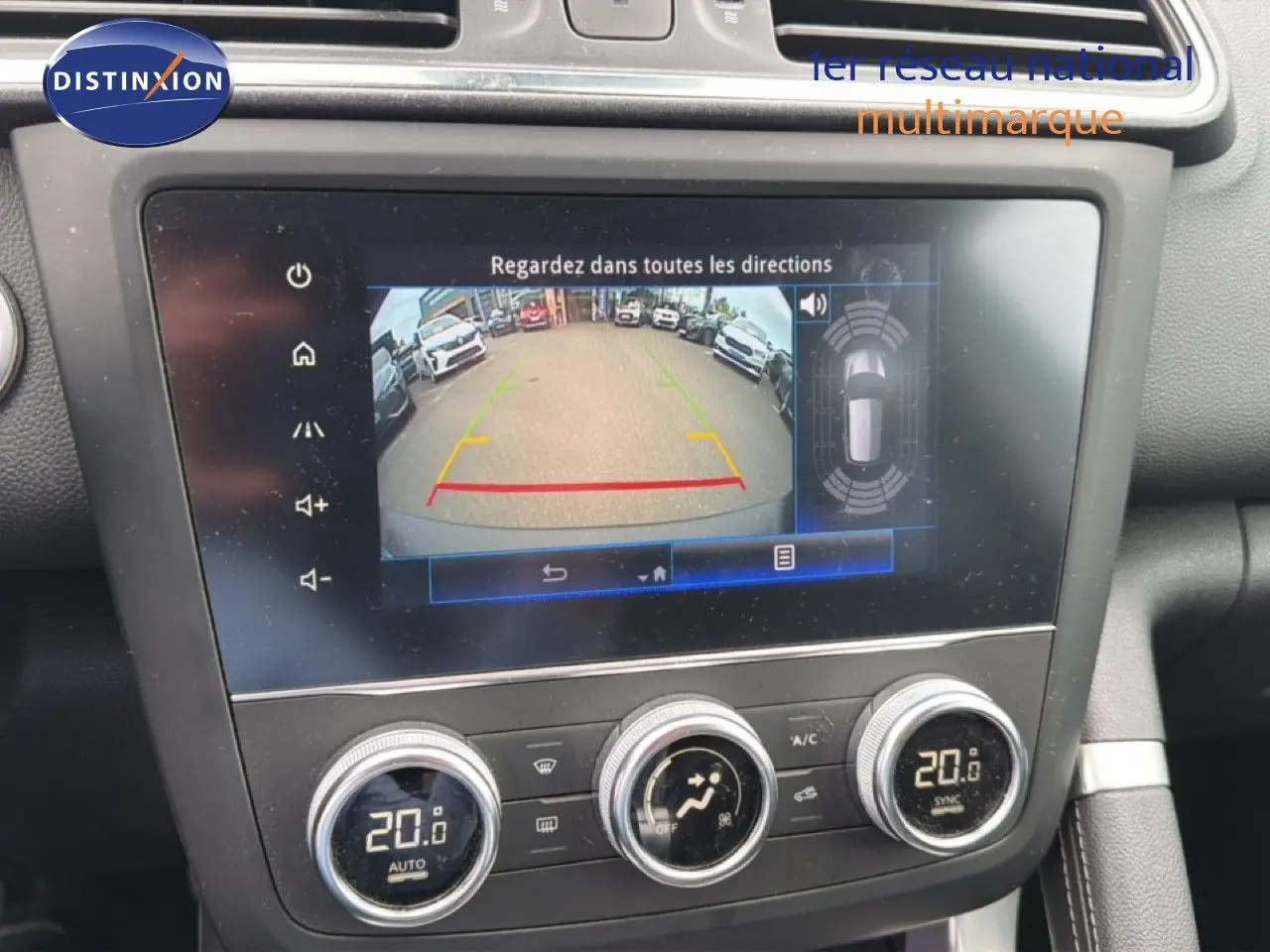 Vue rapprochée de l'écran tactile intérieur du Renault Kadjar bleu Iron, affichant la caméra de recul et la climatisation à 20°C.
