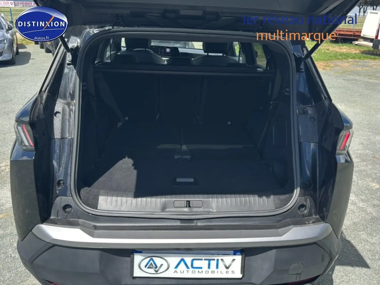 Coffre ouvert vu de l'arrière d'un Peugeot 5008 Hybrid 145 allure e-dcs6 noir avec banquette rabattue.