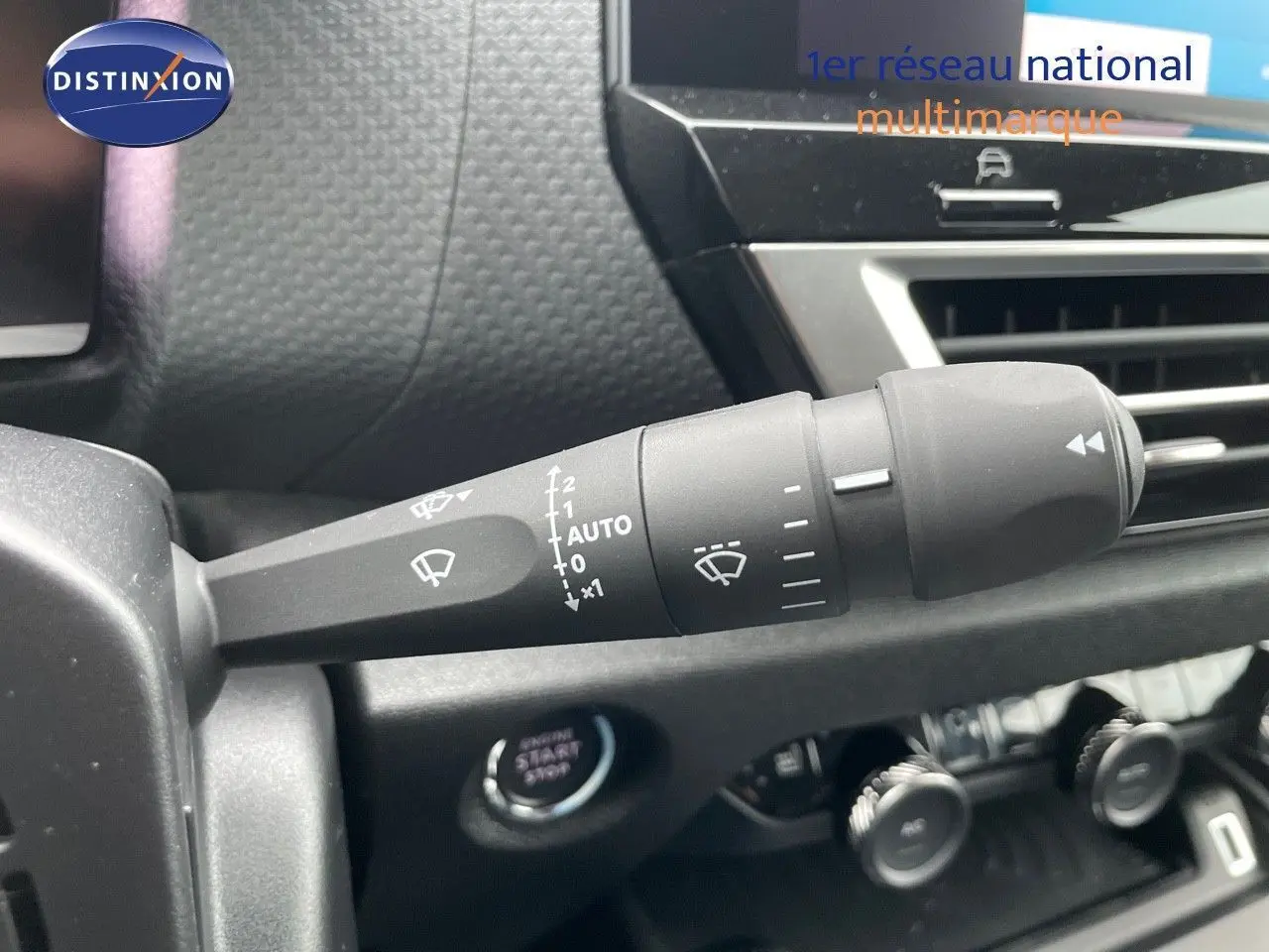 Gros plan sur la commande d’essuie-glace à gauche du tableau de bord d’une Citroën C4 blanche 2024.