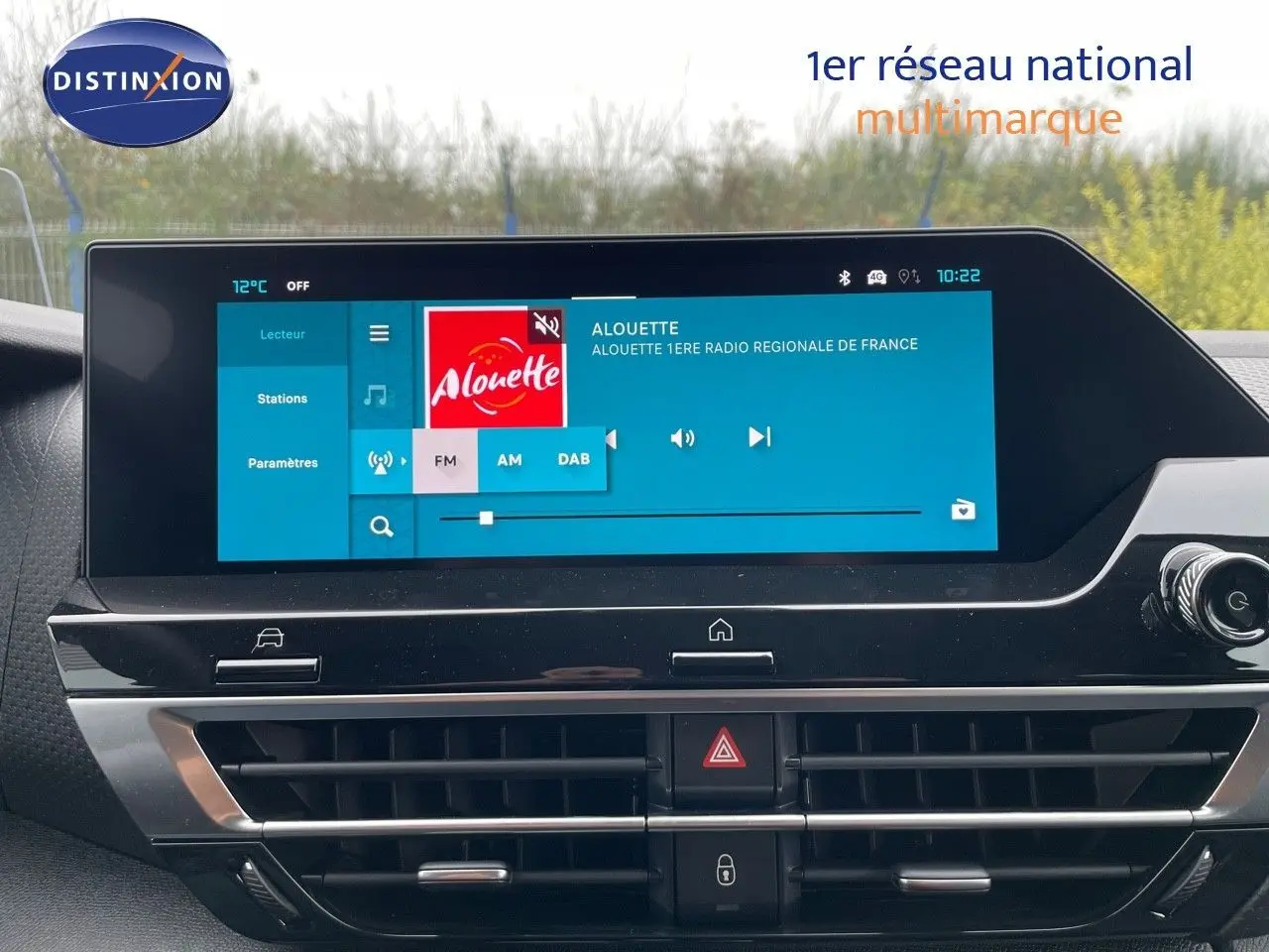 Écran tactile central allumé dans l'habitacle du Citroën C4 blanc métal, affichant une radio FM.