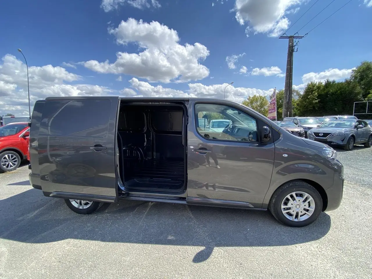 Peugeot Expert Fourgon gris platinium vu de profil droit, porte latérale coulissante ouverte montrant l'intérieur vide.