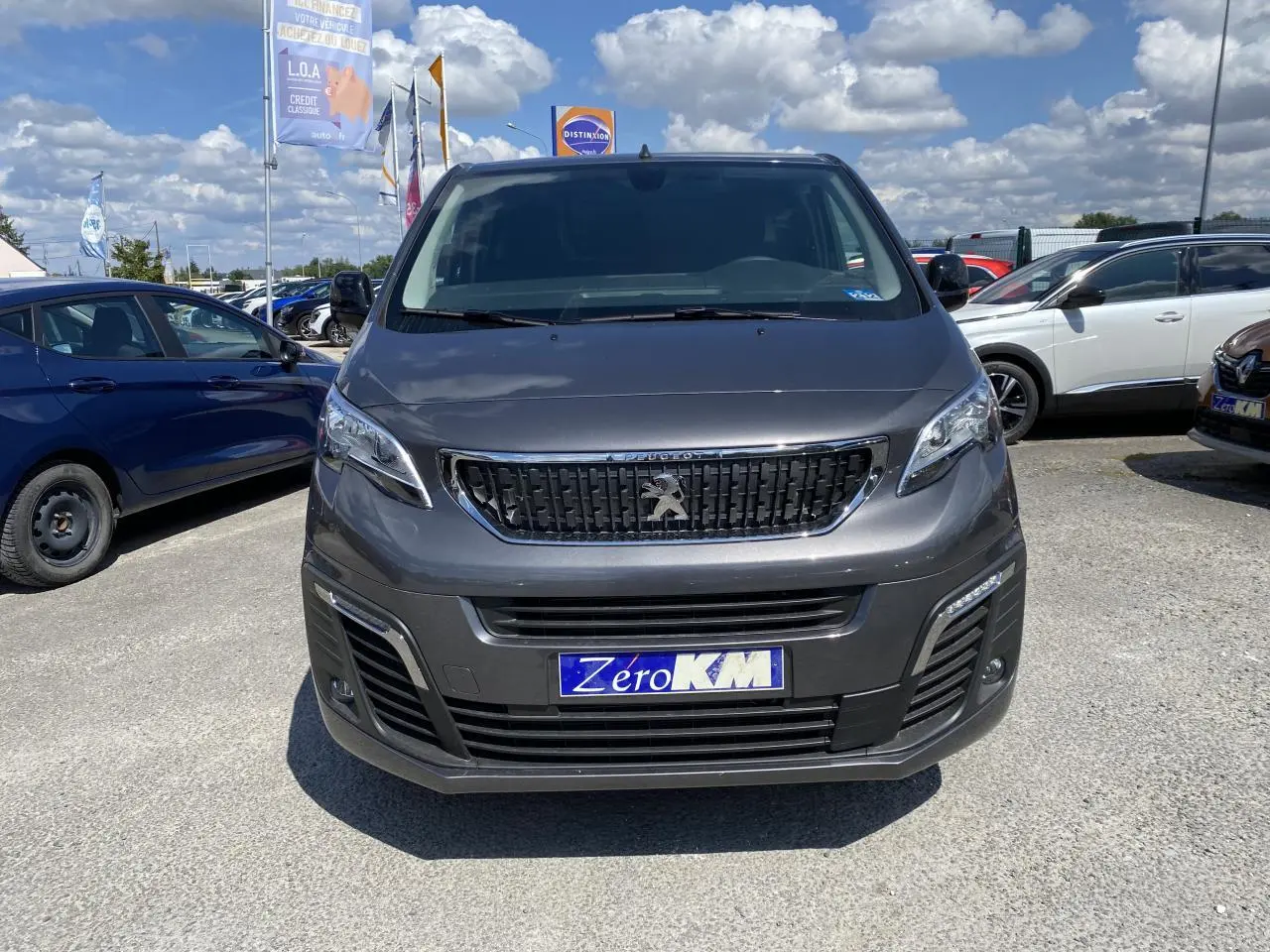 Vue de face d'un Peugeot Expert Fourgon gris platinium 2022 avec calandre noire et plaque Zero KM visible.