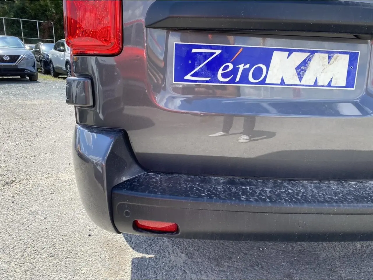 Gros plan sur le pare-chocs arrière gris platinium du Peugeot Expert Fourgon avec plaque Zéro KM visible.