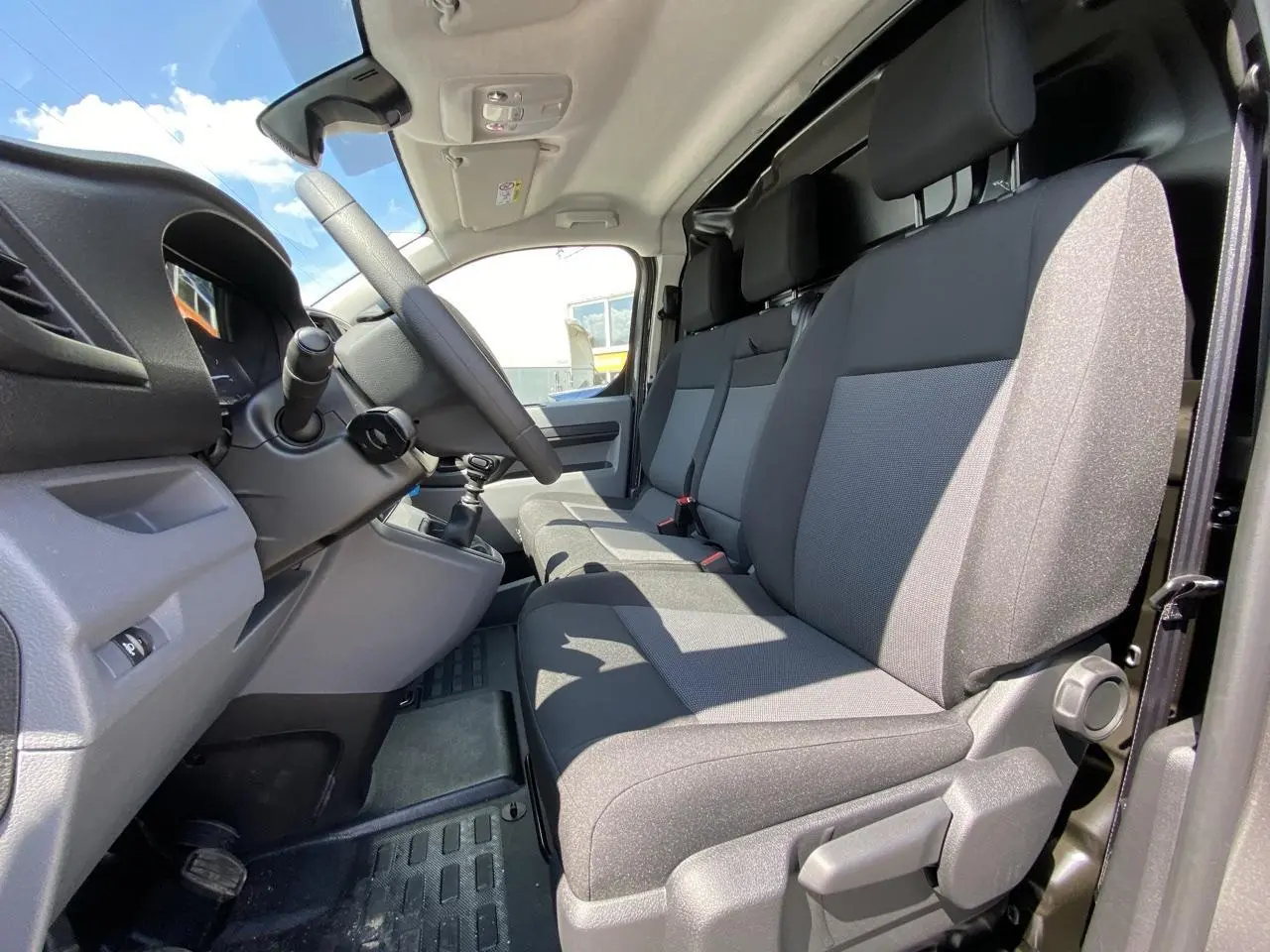 Vue intérieure côté conducteur du Peugeot Expert Fourgon 2022 avec banquette Moduwork en tissu gris.