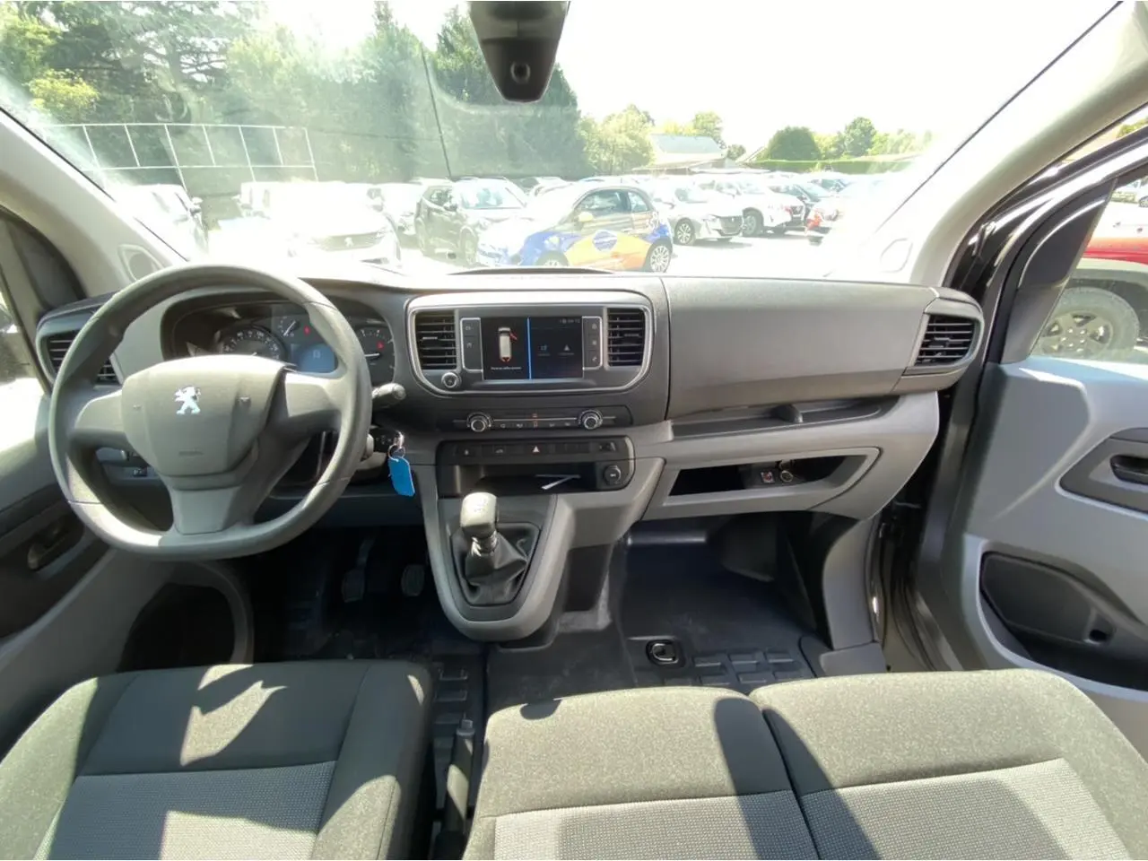 Vue intérieure avant du Peugeot Expert Fourgon gris platinium, montrant le tableau de bord et la banquette Moduwork.