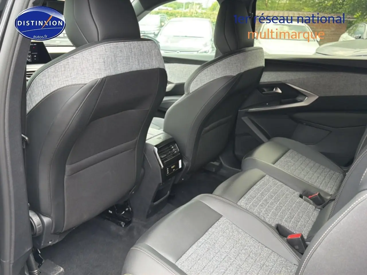 Vue intérieure arrière droite du Peugeot 5008 Hybrid 145 allure 2025 avec sièges en tissu gris et cuir noir.