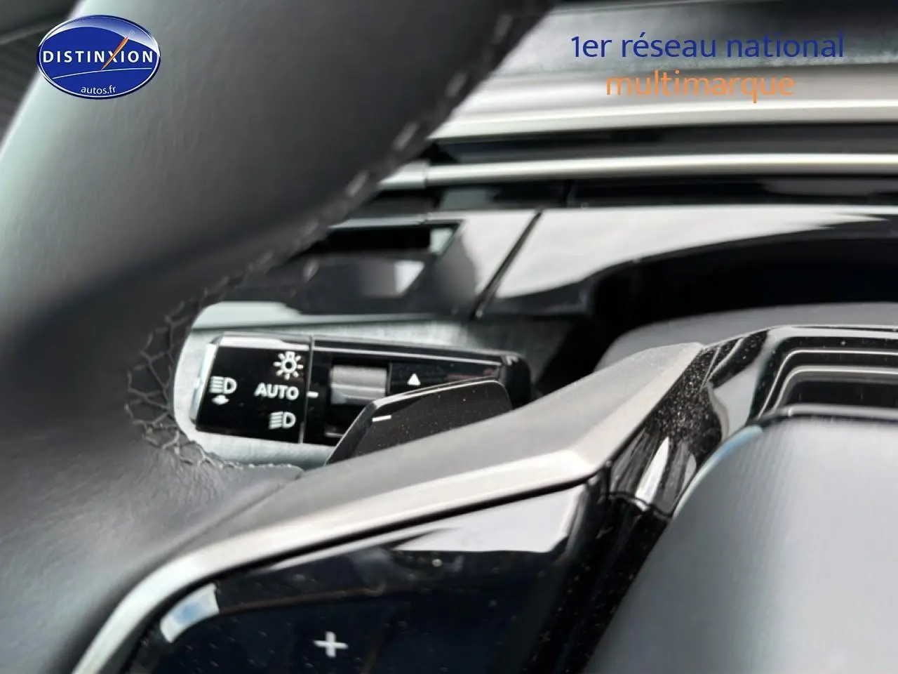 Gros plan sur le volant cuir noir et la commande des phares automatiques du Peugeot 5008 Hybrid 145 allure e-dcs6 2025.