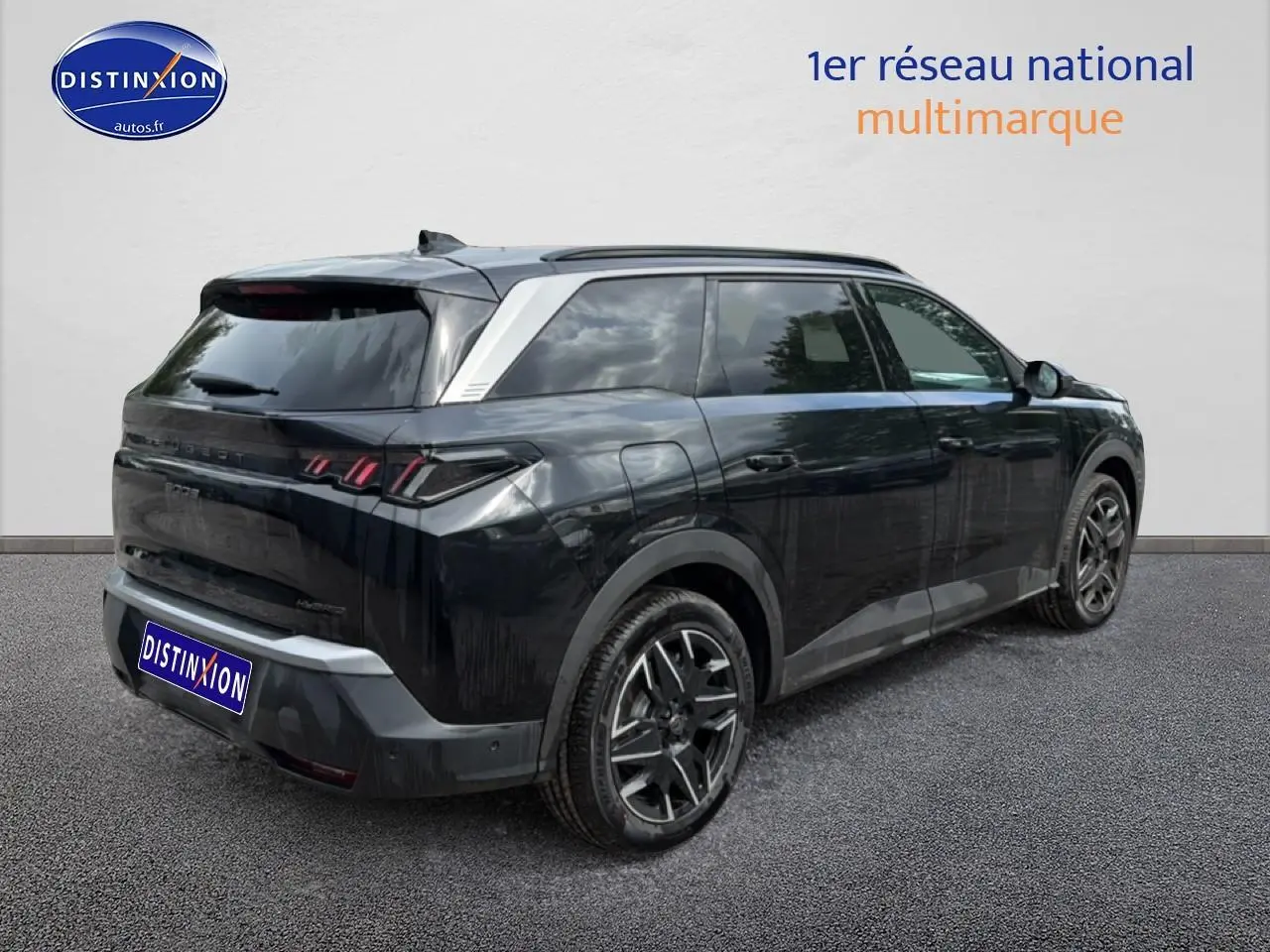 Peugeot 5008 noir vue 3/4 arrière droit, jantes alu et toit avec inserts argentés visibles.