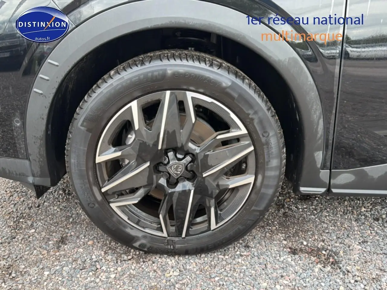 Gros plan sur la roue avant gauche noire du Peugeot 5008 Hybrid 145 allure e-dcs6 avec jante alu distinctive.