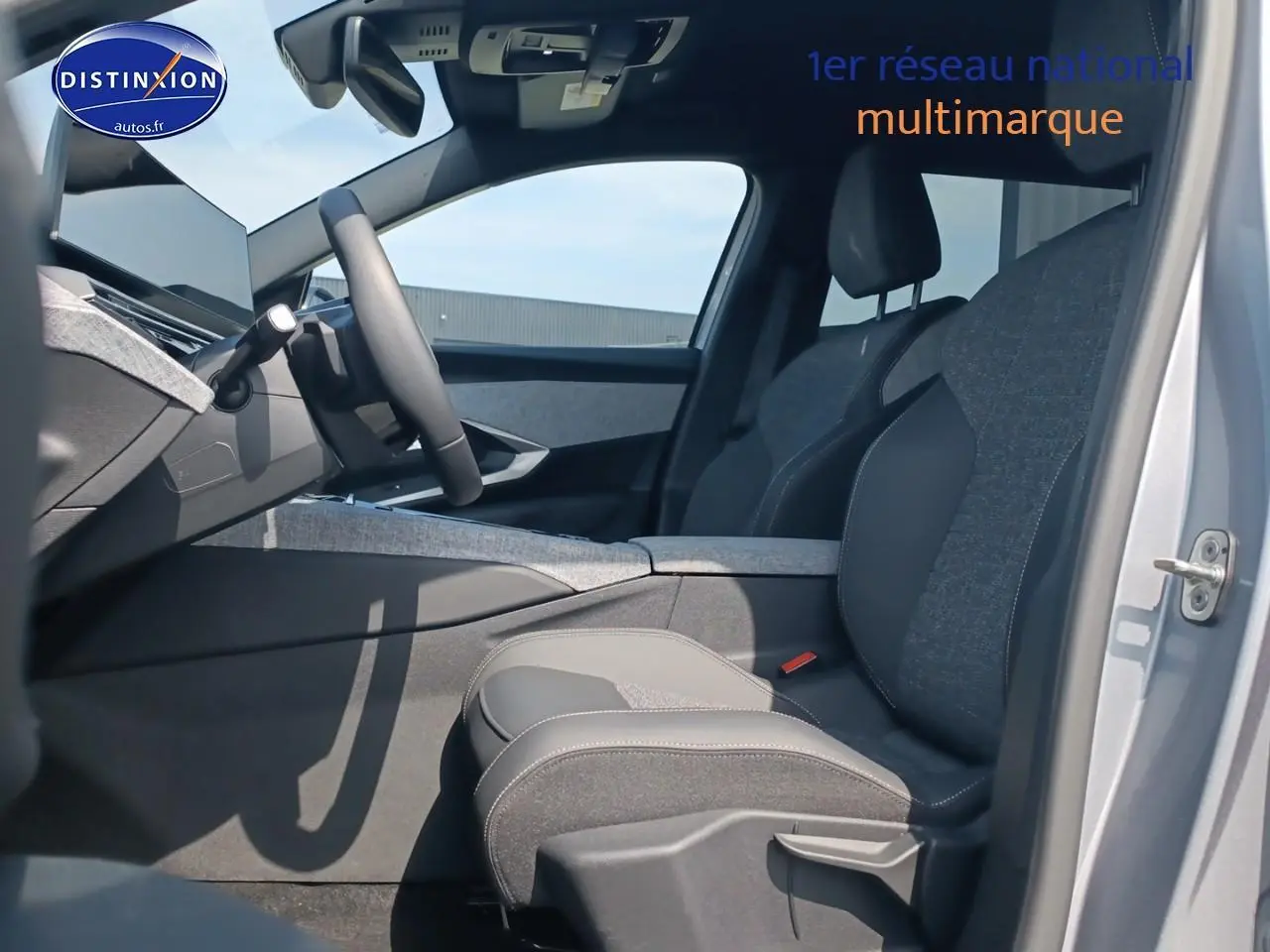 Vue intérieure côté conducteur du Peugeot 5008 gris artense, mettant en valeur les sièges avant en tissu et cuir et le tableau de bord moderne.