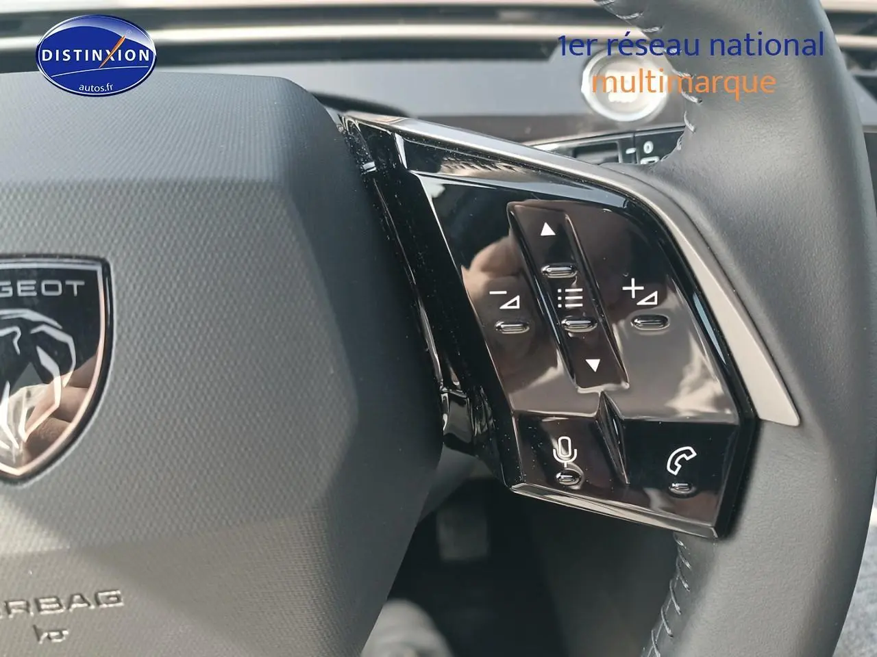 Gros plan sur le volant cuir multifonction du Peugeot 5008 gris Artense, avec commandes vocales et audio intégrées.