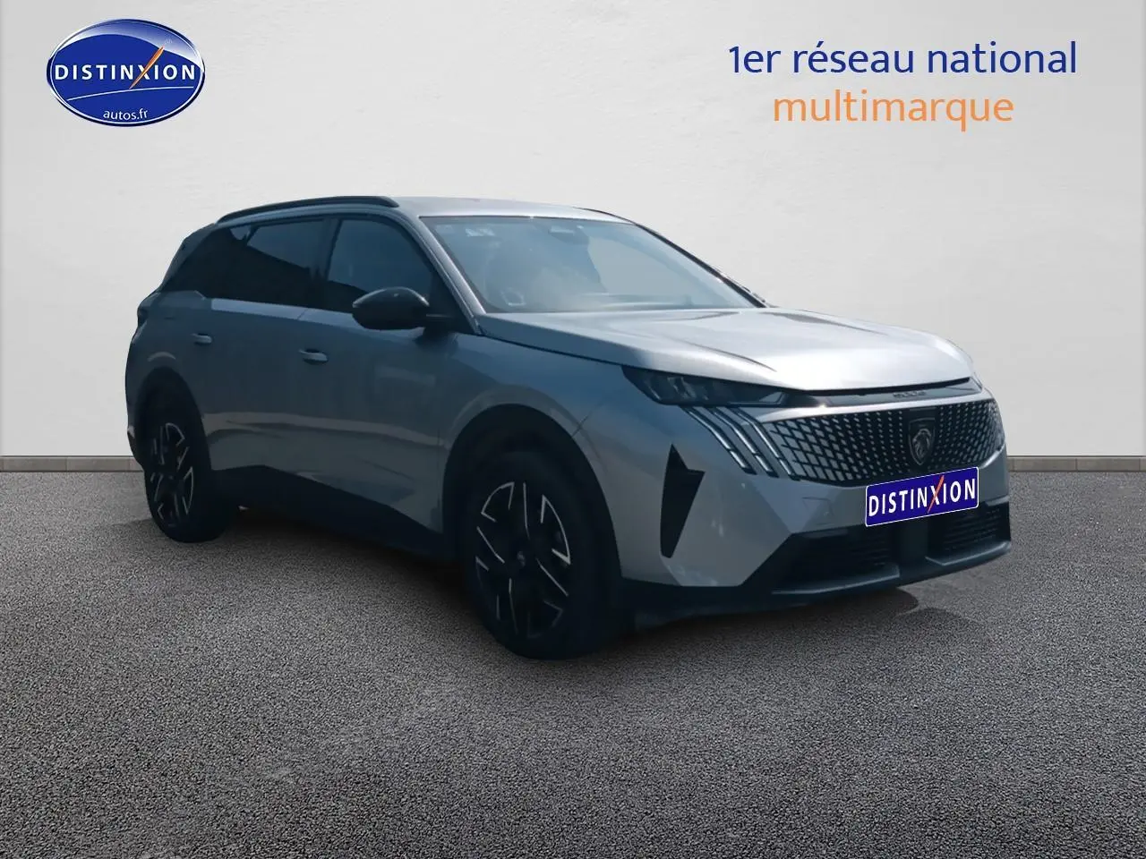Peugeot 5008 Hybrid gris artense en 3/4 avant droit, avec calandre distinctive et jantes noires.