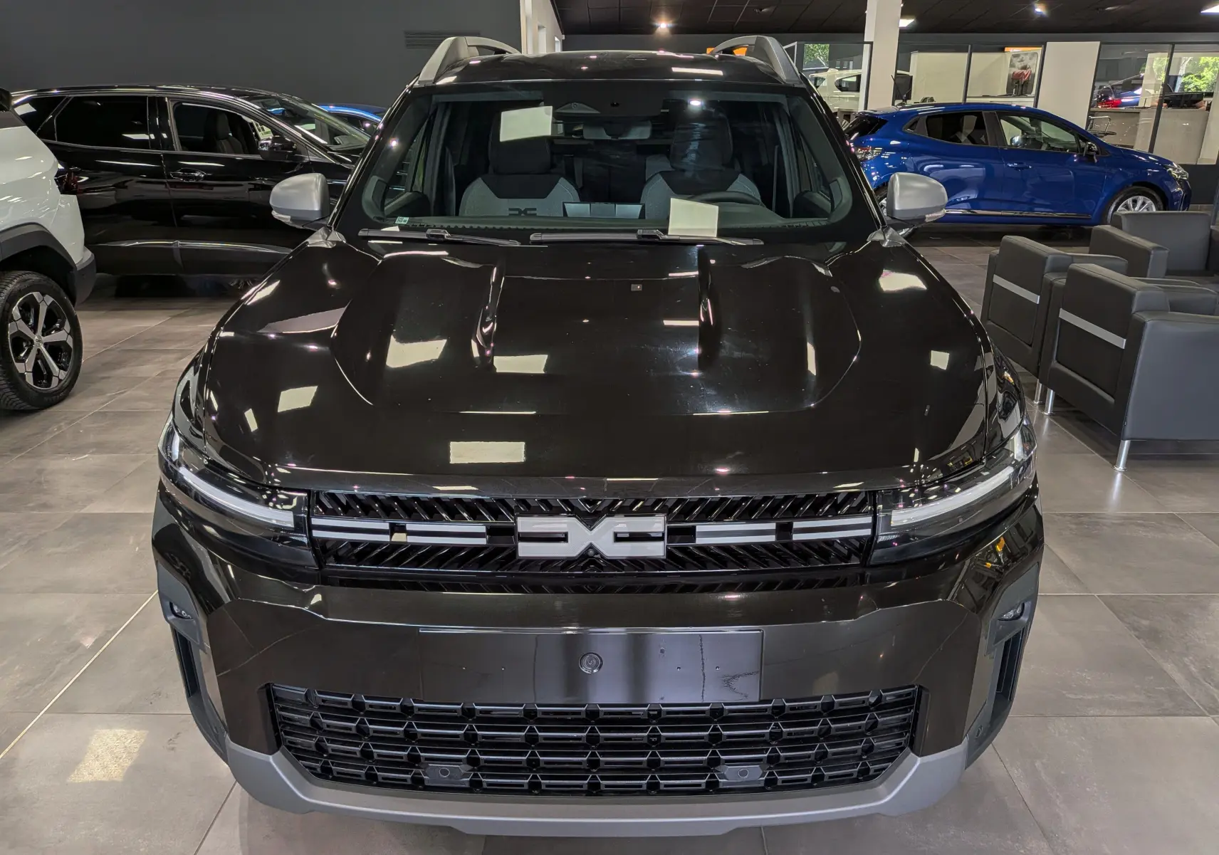 Vue frontale du Dacia Bigster noir nacré 2026 en showroom, mettant en valeur sa calandre distinctive et ses lignes robustes.
