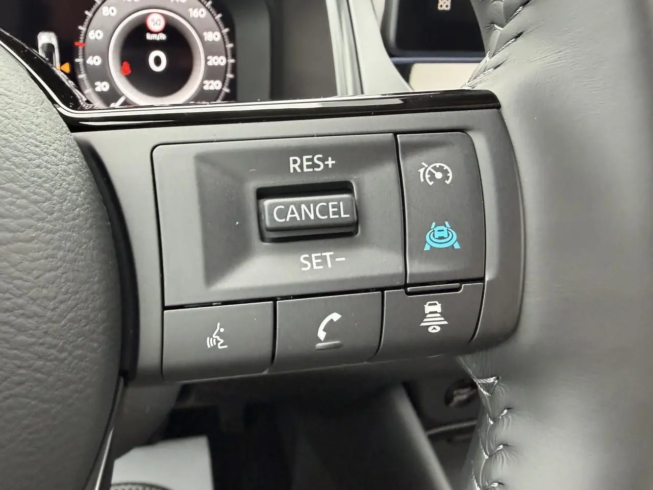 Gros plan sur les commandes du volant à droite du Nissan Qashqai 2025, boutons de régulateur et assistant de conduite visibles.