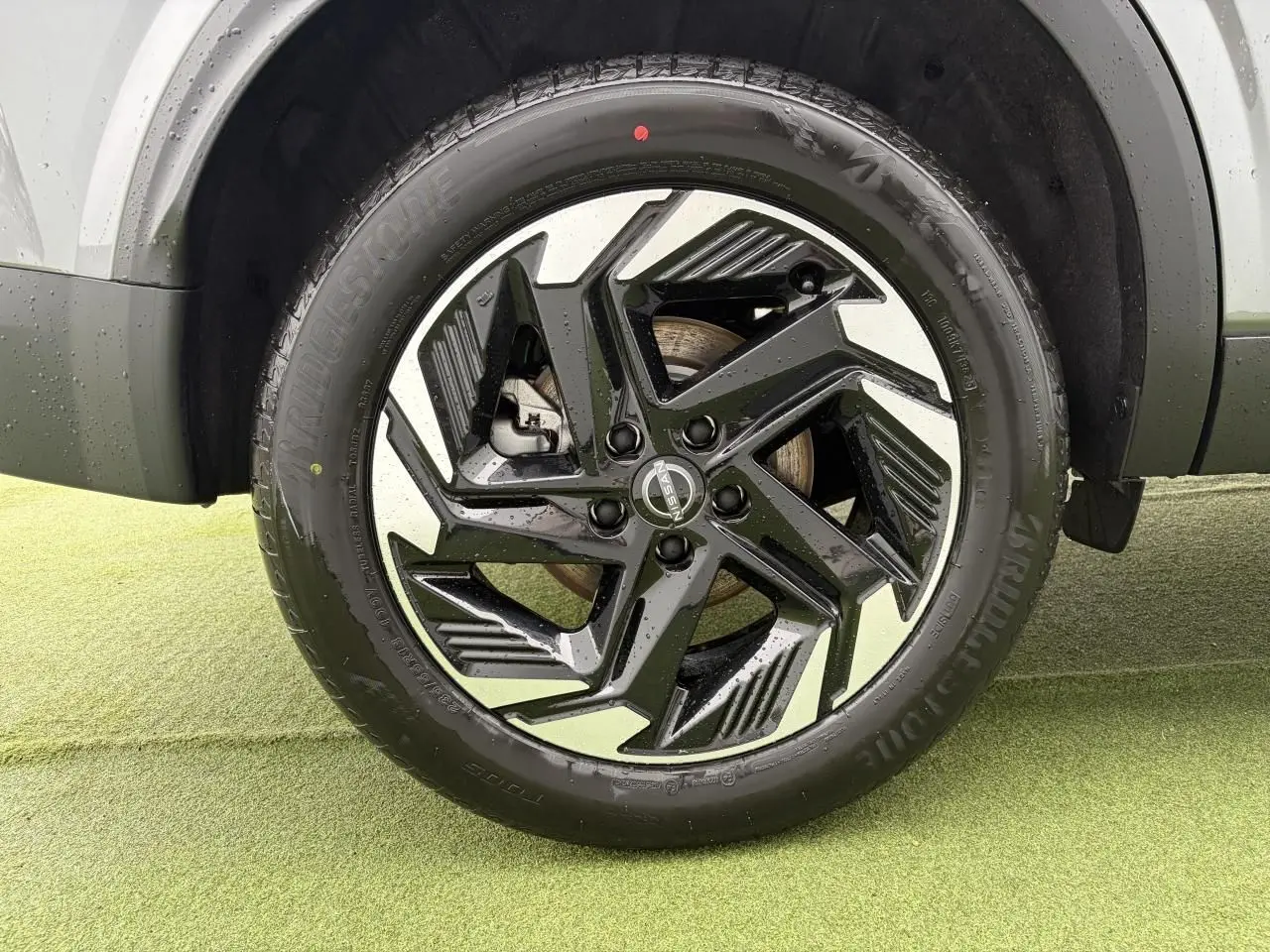 Gros plan sur la jante alliage 18 pouces bicolore noir et argent du Nissan Qashqai III gris foncé, roue avant droite.