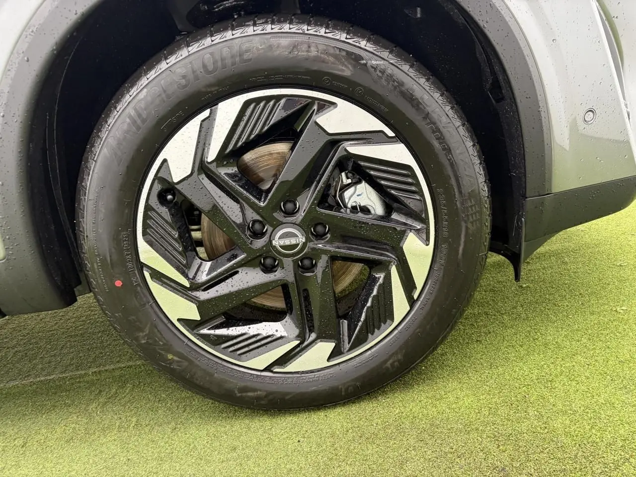 Gros plan sur la jante alliage 18 pouces bicolore noire et argent du Nissan Qashqai III gris foncé, roue avant droite.