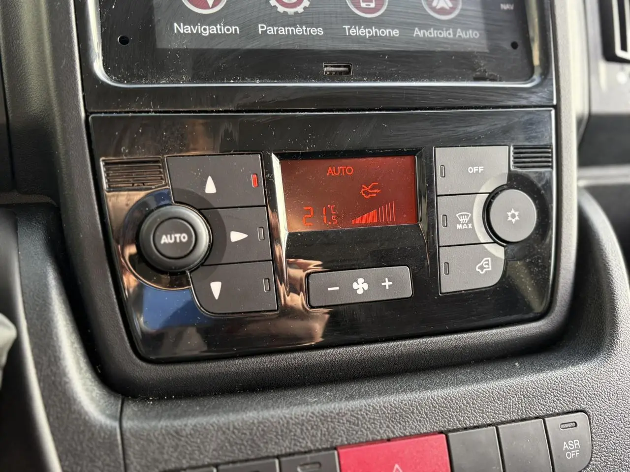 Vue rapprochée du panneau de commande de la climatisation automatique dans l’habitacle de l’Opel Movano Fourgon blanc.