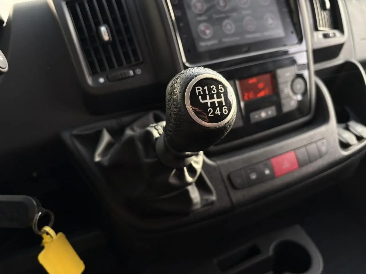 Gros plan sur le levier de vitesses manuel noir dans l’habitacle sombre de l’Opel Movano Fourgon 2024.