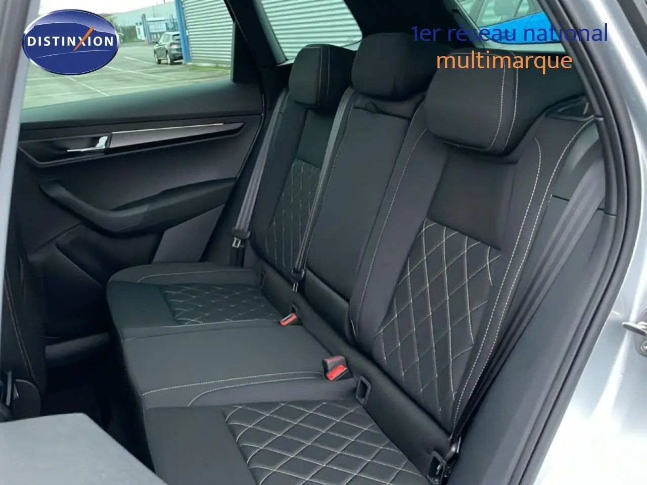 Vue intérieure des sièges arrière en tissu noir avec surpiqûres contrastantes d'un Skoda Karoq gris argent 2025.