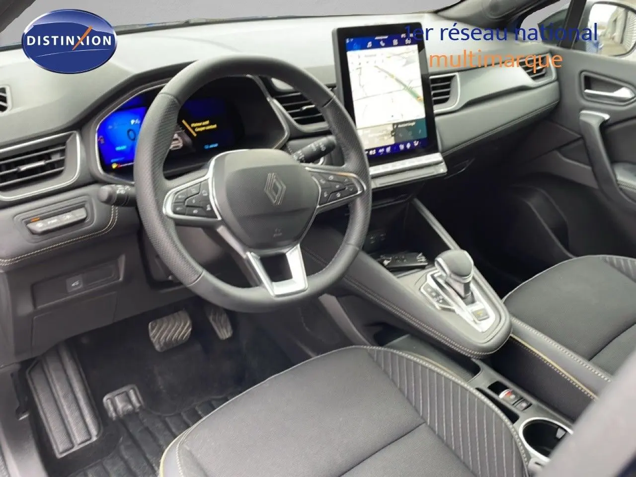 Vue intérieure avant droite du Renault Symbioz 2025, volant multifonction, écran tactile vertical et sellerie noire.