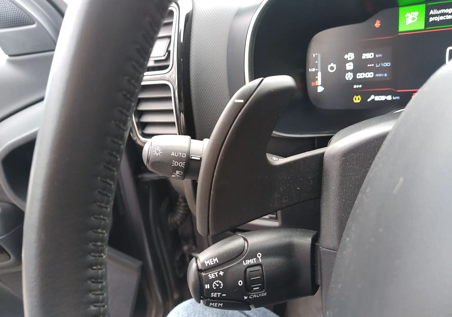 Gros plan sur la commande au volant côté gauche du Citroën C5 Aircross gris platinium, avec affichage numérique en arrière-plan.