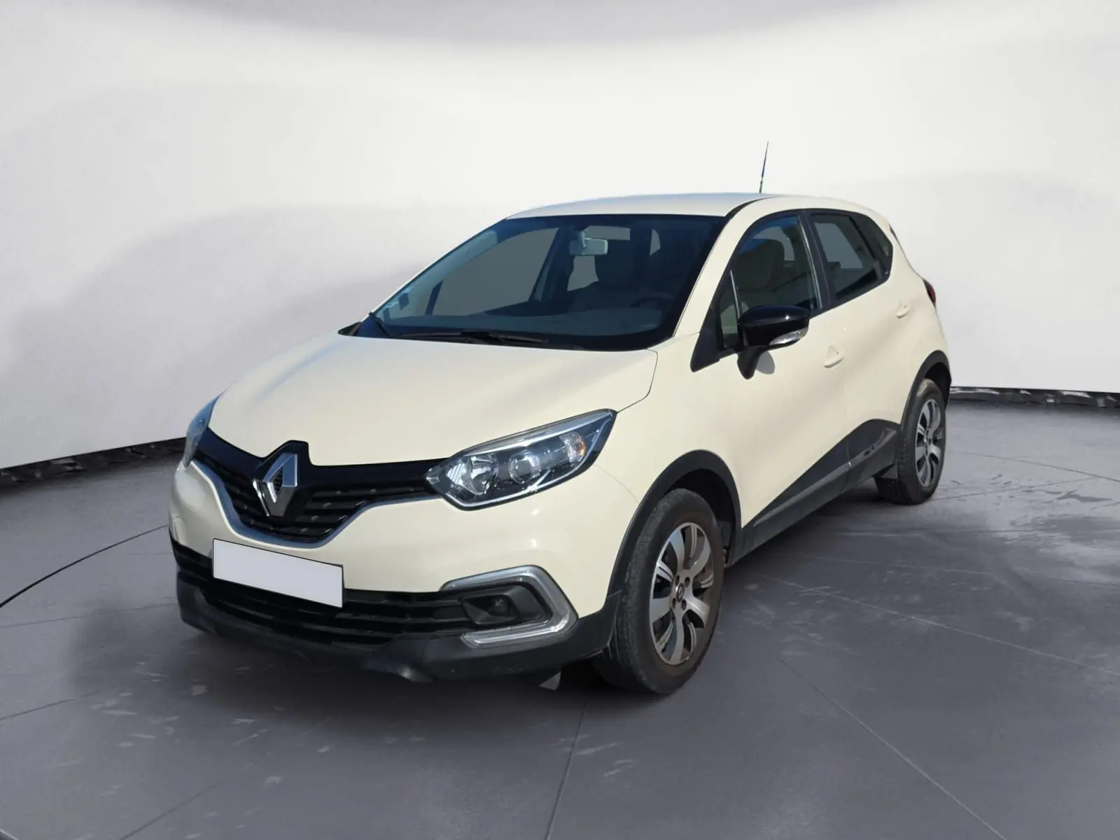 Renault Captur ivoire en 3/4 avant droit, avec jantes alliage et rétroviseurs noirs contrastants.
